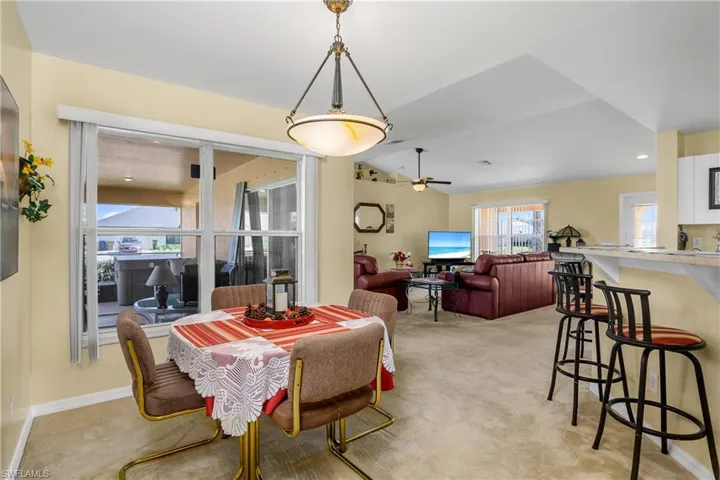Dining area featuring a ceiling fan, light colored carpet, and baseboards