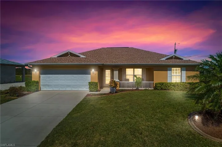 Ranch-style home featuring stucco siding, covered porch, concrete driveway, an attached garage, and a front yard