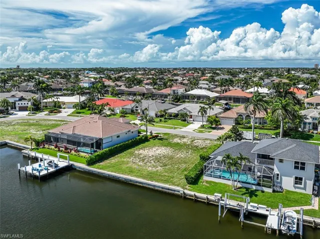 Aerial view of residential area featuring a nearby body of water