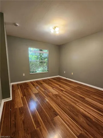 Empty room with wood finished floors and a smoke detector