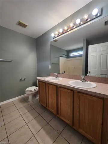 Full bath with double vanity and tile patterned flooring