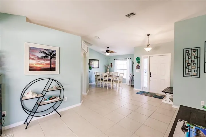 Tiled foyer entrance featuring lofted ceiling and ceiling fan