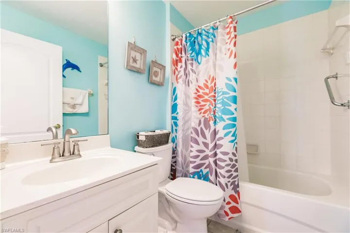 Full bathroom featuring oversized vanity, toilet, and shower / bath combination with curtain