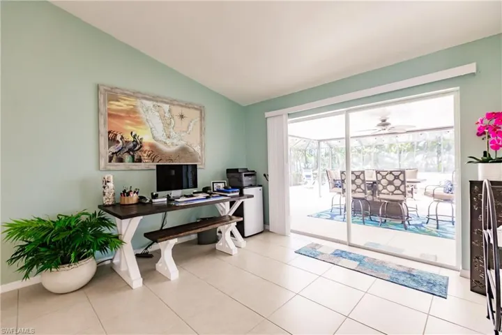 Office space featuring vaulted ceiling, ceiling fan, and light tile flooring
