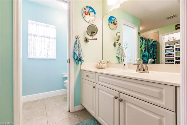 Bathroom with tile flooring, vanity, and toilet