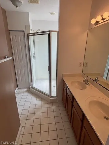Bathroom featuring a double vanity with integrated sinks and a large mirror