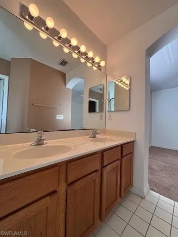 Dual vanity with wood-finish cabinetry and integrated sinks