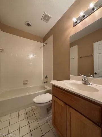 Bathroom featuring a white subway tile surround, white bathtub, and white square floor tiles