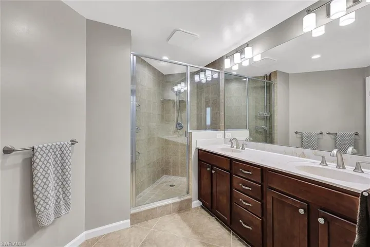 New faucets are on the dual sinks, and there is a walk-in shower.