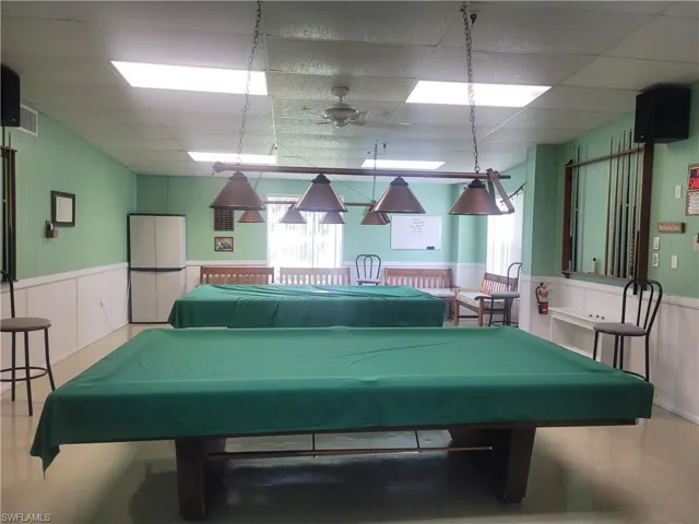 Rec room featuring a wainscoted wall, ceiling fan, a paneled ceiling, and pool table
