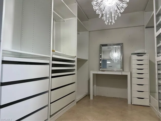 Built-in shelving with integrated drawer storage and a decorative chandelier