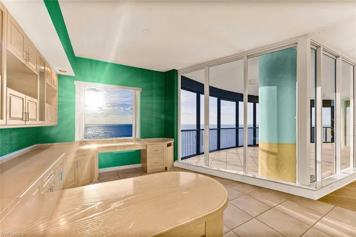 Kitchen featuring light tile patterned floors, built in study area, and light countertops
