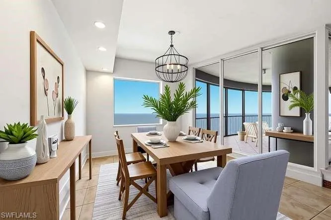 Spacious room featuring floor-to-ceiling sliding glass doors, a large picture window, and direct access to an expansive outdoor balcony with metal railings and water views