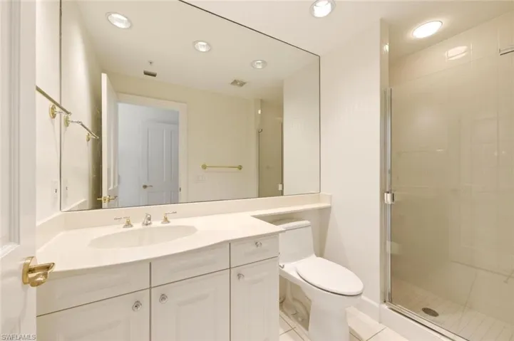 Spacious closet featuring light-toned wood shelving, white walls, and light-colored carpeting