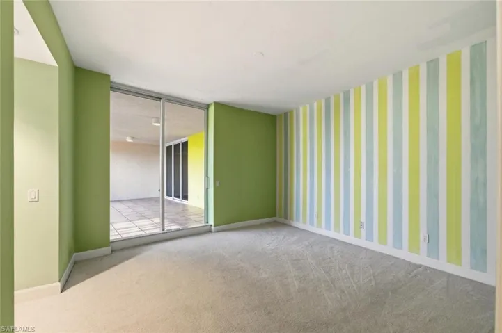 Empty room featuring carpet and wallpapered walls
