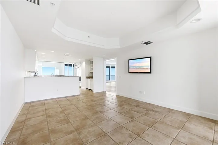 Spacious room featuring tile flooring, white baseboards, and bright white walls