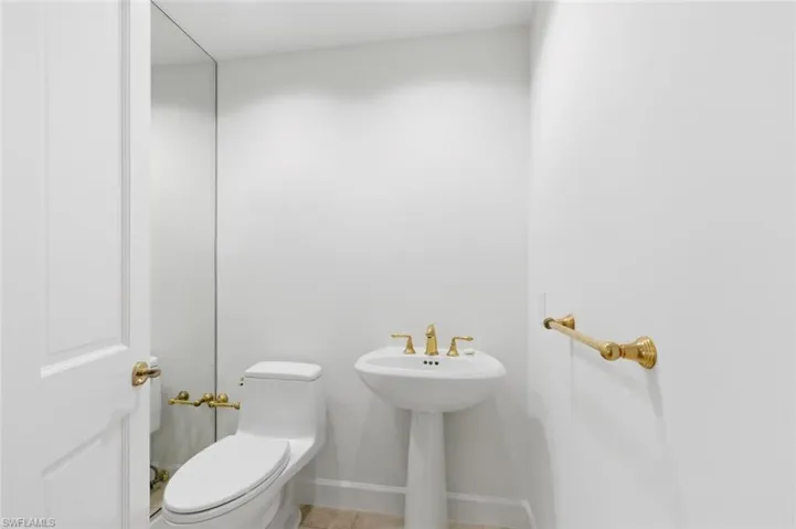 Spacious room with large-format tile flooring, a horizontal window, and a wall of sliding glass doors opening to a private balcony