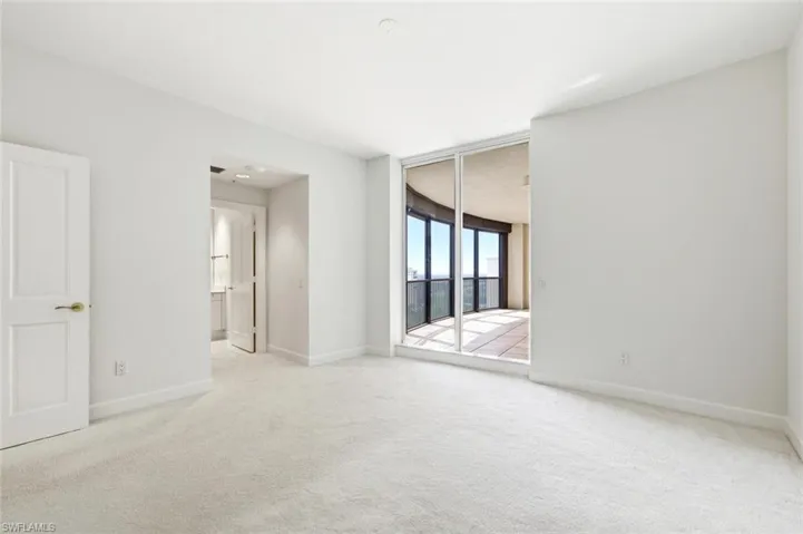 Bright interior featuring a prominent window, white carpeting, white walls, and white trim