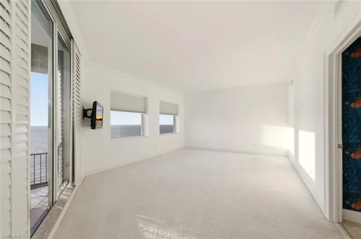 Carpeted empty room featuring crown molding