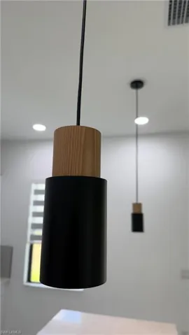 Contemporary pendant lighting featuring a matte black finish with wood-finish accents