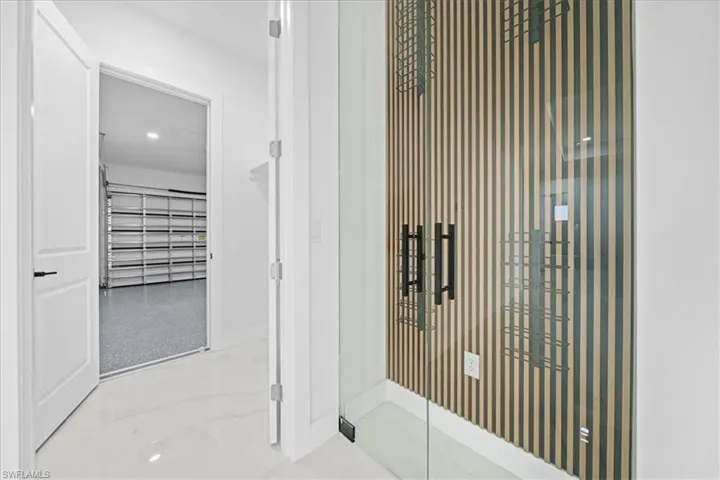 Modern glass-paneled entry featuring vertical slat wood-finish detailing and contemporary black hardware