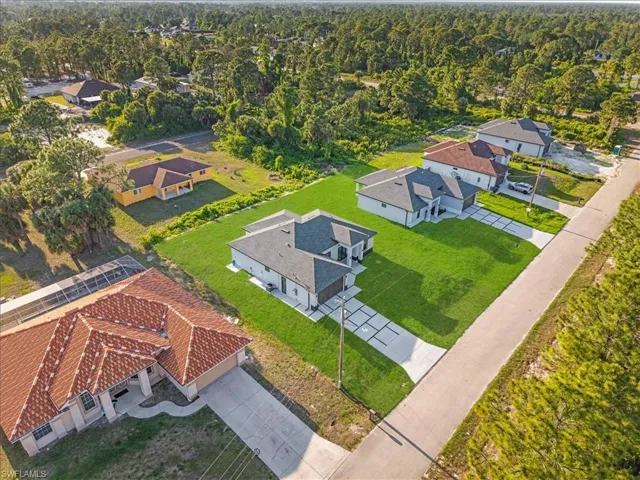 Newly constructed residence featuring a contemporary design, dark shingle roofing, a two-car garage, and a concrete driveway