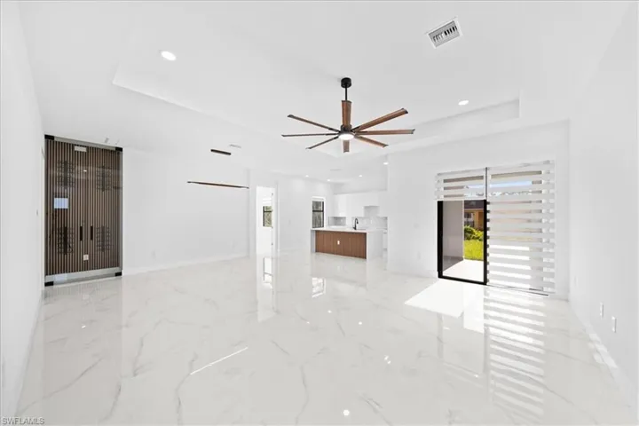 Spacious living area featuring polished tile flooring, recessed lighting, and a modern ceiling fan