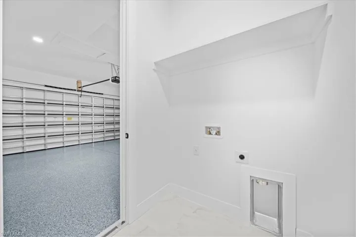 Bright utility area featuring a built-in shelf, white walls, and light-toned flooring