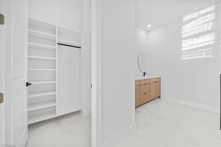 Built-in closet shelving and hanging rod with white paneled door and dark hardware