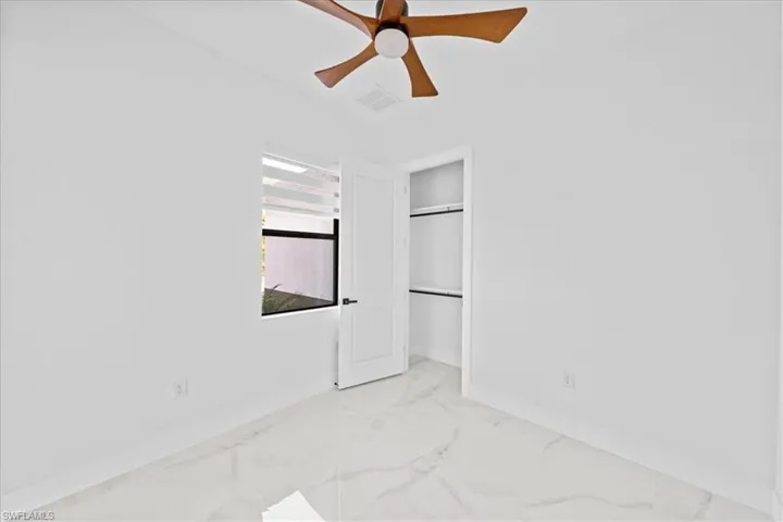 Bright interior space featuring white walls and marble-look tile flooring