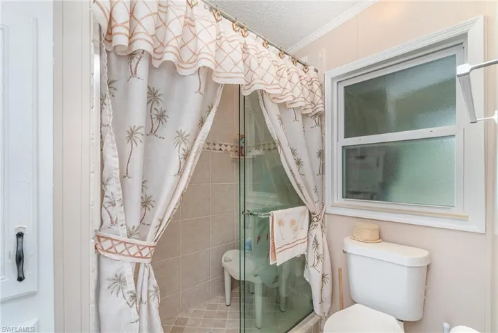 Bathroom featuring crown molding, a textured ceiling, and toilet