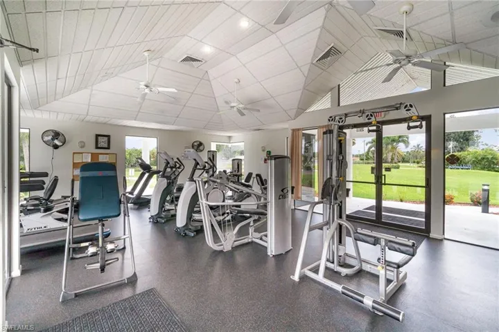 Gym featuring ceiling fan, vaulted ceiling, and a paneled ceiling