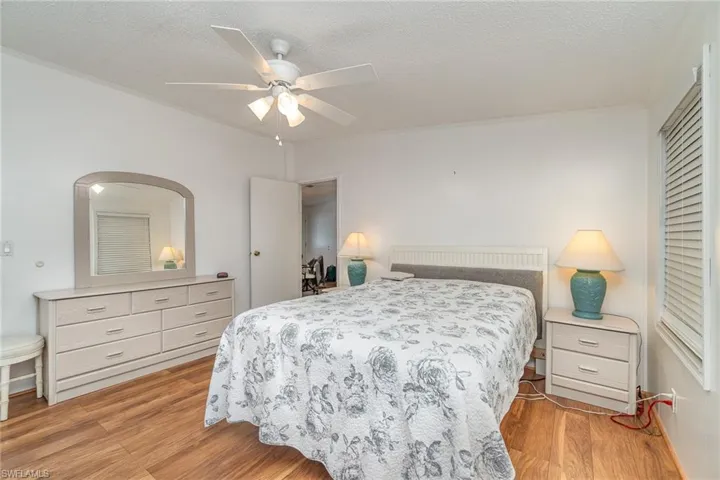 Bedroom with ceiling fan, a textured ceiling, and light hardwood / wood-style floors