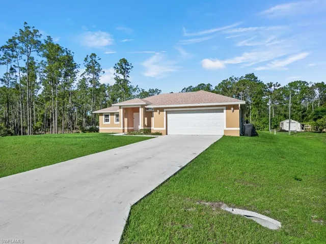 Ranch-style house with a front lawn, stucco siding, an attached garage, and concrete driveway