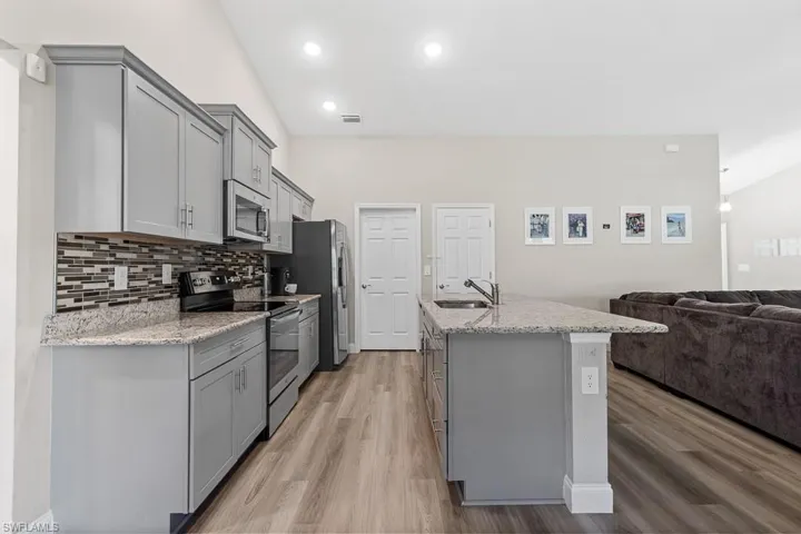Kitchen featuring a sink, gray cabinets, and appliances with stainless steel finishes