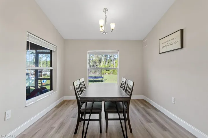 Dining room with plenty of natural light, baseboards, and a chandelier