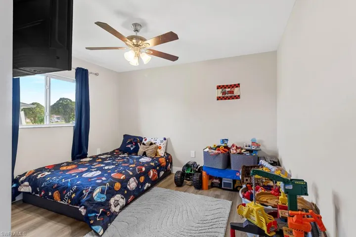 Bedroom with a ceiling fan, baseboards, and wood finished floors