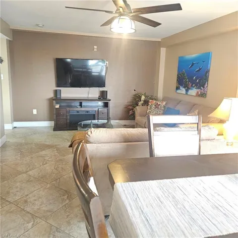 Living room featuring a ceiling fan and crown molding