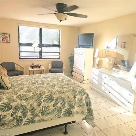 Bedroom with light tile patterned floors and ceiling fan