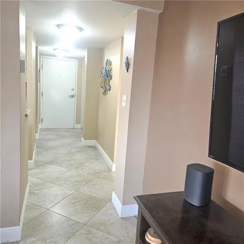 Corridor with baseboards and light tile patterned floors