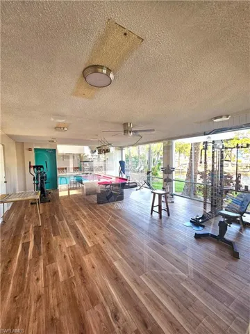 Workout area with a wall of windows and a textured ceiling