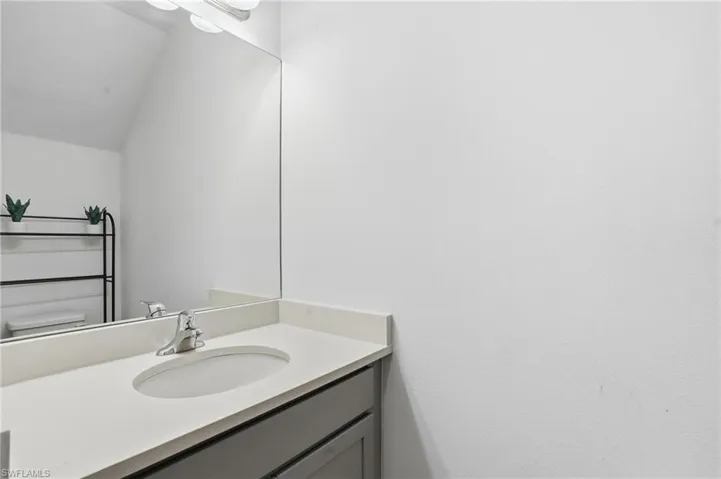 Half bath featuring vanity and vaulted ceiling