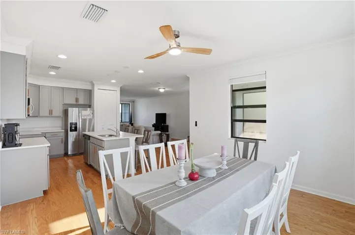 Dining space featuring crown molding, light wood-style floors, a ceiling fan, recessed lighting, and plenty of natural light