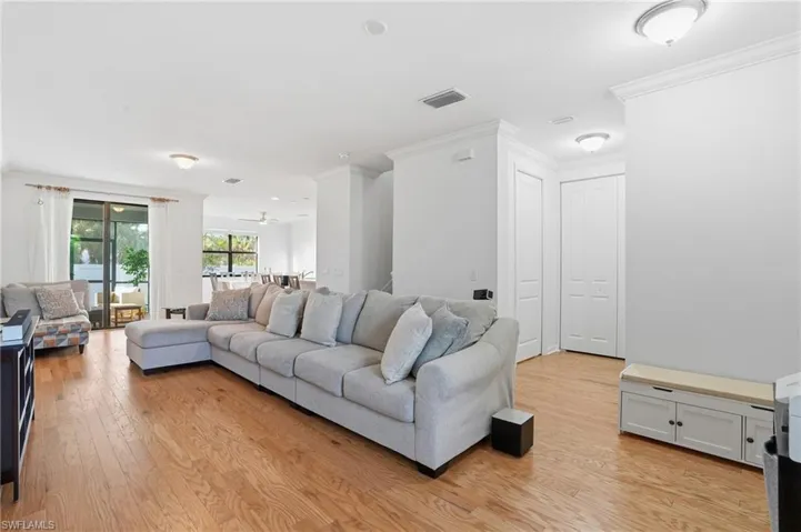 Living room featuring crown molding and light wood-type flooring