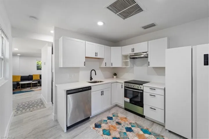 Kitchen with a sink, visible vents, light countertops, white cabinets, and appliances with stainless steel finishes
