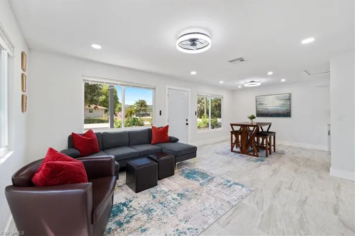 Living room featuring baseboards, visible vents, marble finish floor, and recessed lighting