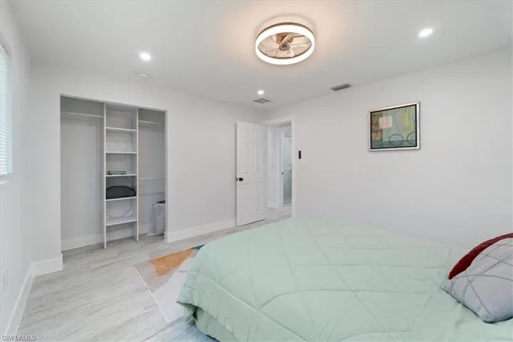 Bedroom with baseboards, visible vents, and light wood-style floors