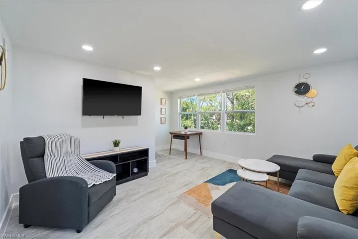 Living room with baseboards, recessed lighting, and wood finished floors