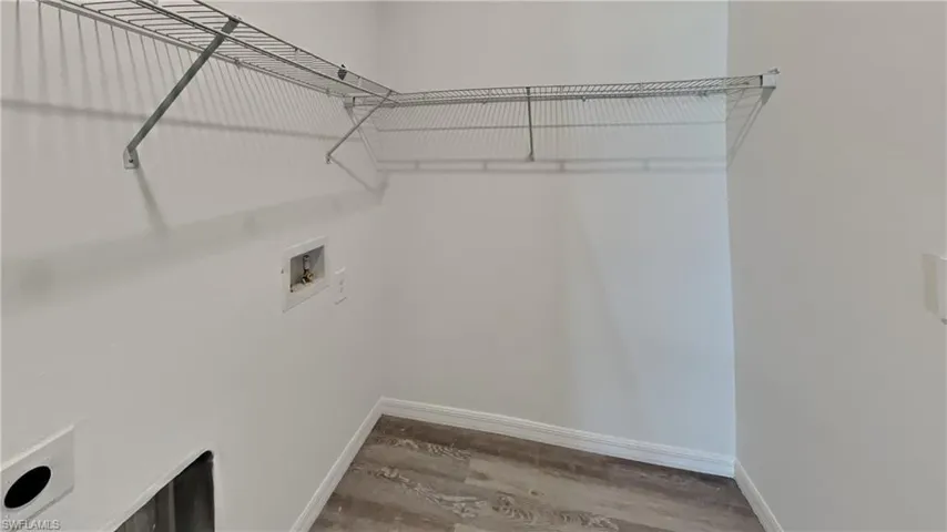 Laundry area with hookup for a washing machine and light wood finished floors