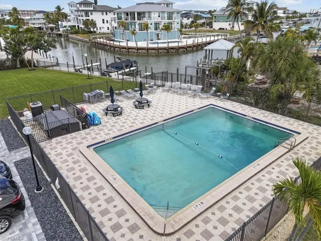 Community pool with a patio area, a water view, and a residential view